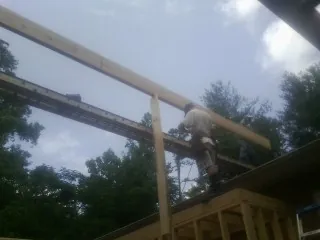 Carpenter setting a ridge beam over a new addition frame — Ice Dam Removal by Roofing Brothers in York