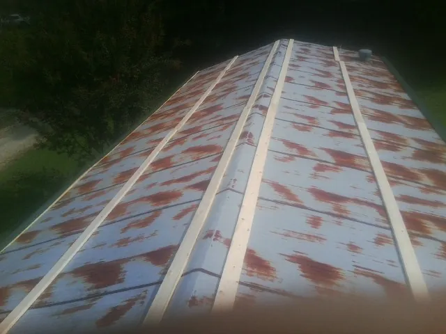 Rusted metal roof panels with new wood purlins before replacement — Storm Damage Roof Repair in York by Roofing Brothers