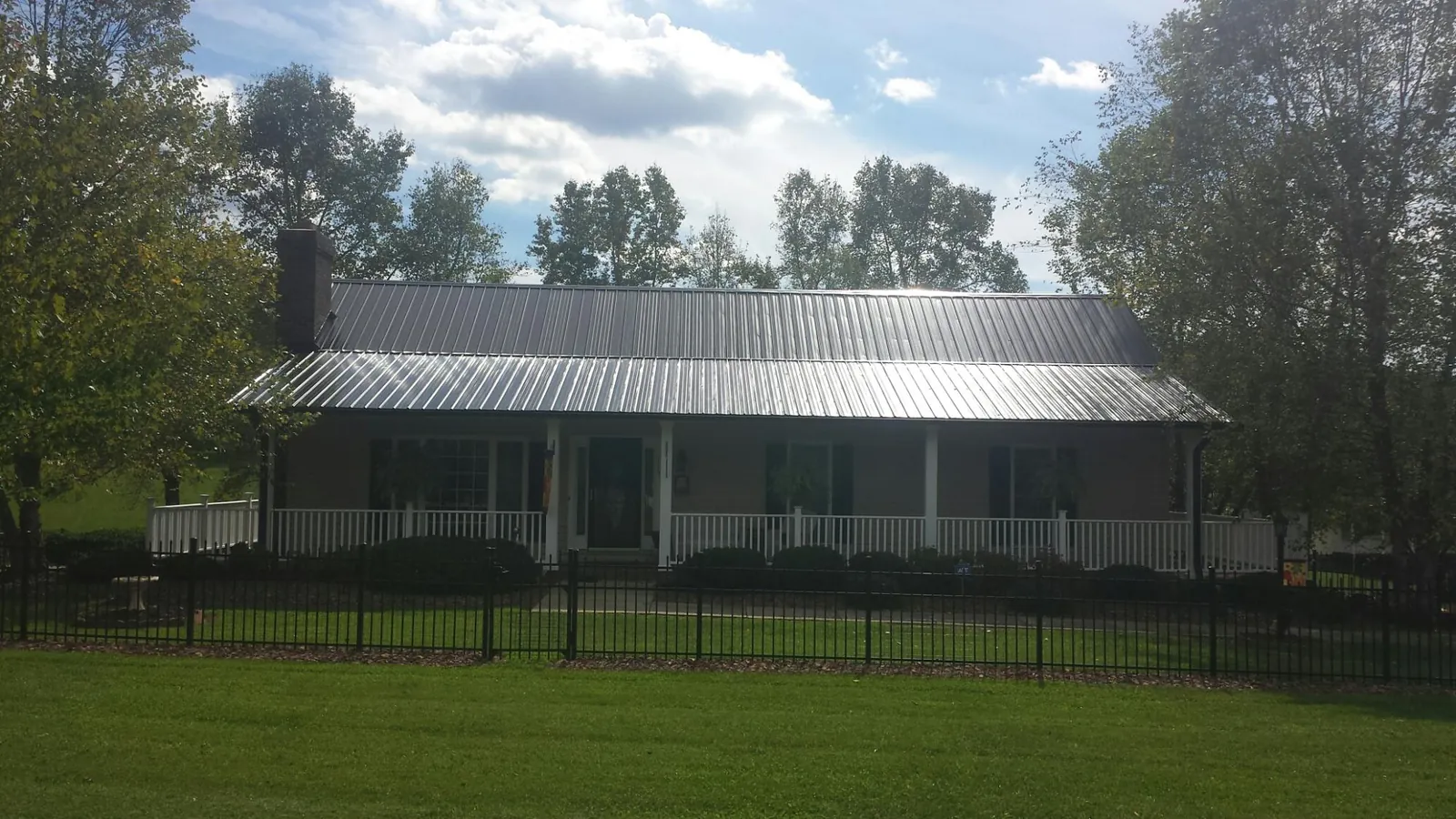 Gray metal roof on a brick ranch with a full width front porch — Gutter Guard Installation work by our crew in York